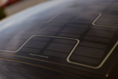 Milan, İtalya. 4 Haziran 2025. Balıkçı otomobilin güneş paneli çatısı güneşte şarj oluyor. Sürdürülebilir ulaşımı teşvik ediyor.