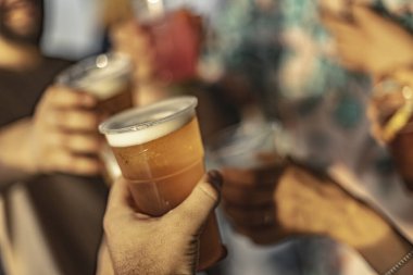 Milan, İtalya 4 Haziran 2025, eller plastik bardak tutuyor, dostça bir atmosferde kadeh kaldırıyor.