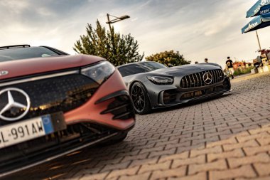 Milan, İtalya 4 Haziran 2025, iki Mercedes Benz 'in alçak açılı görüntüsü kaldırım taşlı bir caddeye park edilmiş, lüks ve otomotiv tasarımı sergileniyor.