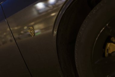 Milan, İtalya 4 Haziran 2025, Altın şeytan logosu bir Dodge Srt şeytan kaslı arabasının yanında sergileniyor.