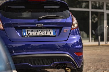 Milan, İtalya 4 Haziran 2025, bir galerinin önünde park etmiş mavi bir Ford Fiesta 'nın arka tarafında, plakasını ve St. Logo' sunu vurguluyor.