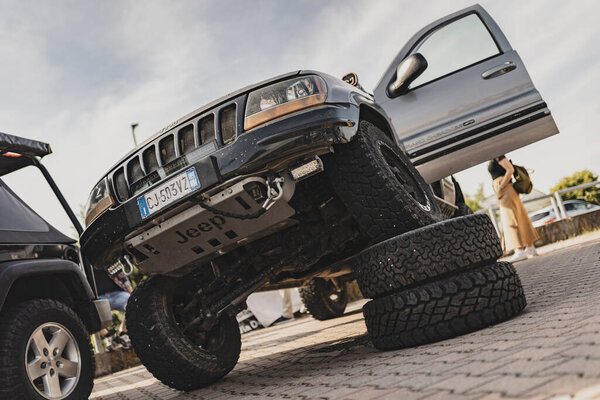 Милан, Италия 4 июня 2025 года, тюнинг джип Cherokee xj с открытой дверью, подвеска и большие внедорожные шины, припаркованные на асфальтированной поверхности