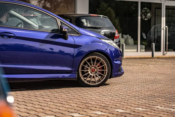 Milan, İtalya 4 Haziran 2025, şık mavi Ford Fiesta st. Pazar sonrası Oz yarış tekerlekleri sergileniyor, bir galeriye park edilmiş, modern araba modifikasyonunu somutlaştırıyor.