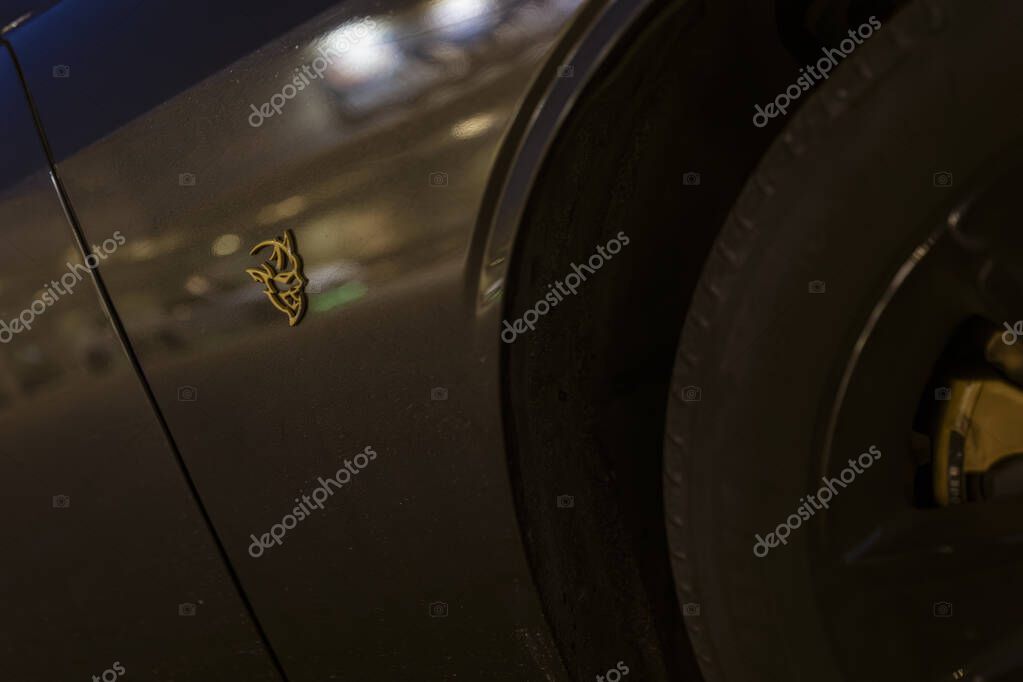 Milan, italy 4 june 2025, gold devil logo is displayed on the side of a dodge challenger srt demon muscle car