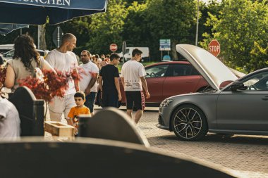 Milan, İtalya 4 Haziran 2025, kaputu açık gri bir araba, muhtemelen bozuk, kentsel bir çevrede insanlar yürüyor, araba arızası veya bakım öneriyor.