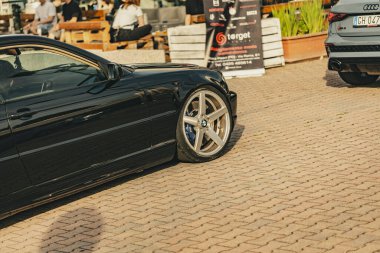 Milan, İtalya 4 Haziran 2025, bir araba toplantısı ya da sergi sırasında parlayan siyah bir BMW park etmiş.