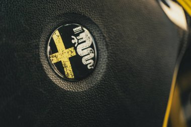 Milan, İtalya 4 Haziran 2025, siyah deri direksiyon simidi simgesel alfa romeo logosu sergiliyor, İtalyan otomotiv tasarımı ve mirasını kutluyor.