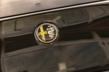 Milan, İtalya 4 Haziran 2025, yıpranmış alfa romeo logosu bulunan parlak siyah araba gövdesi, marka tanıma ve otomotiv tarihini vurguluyor.