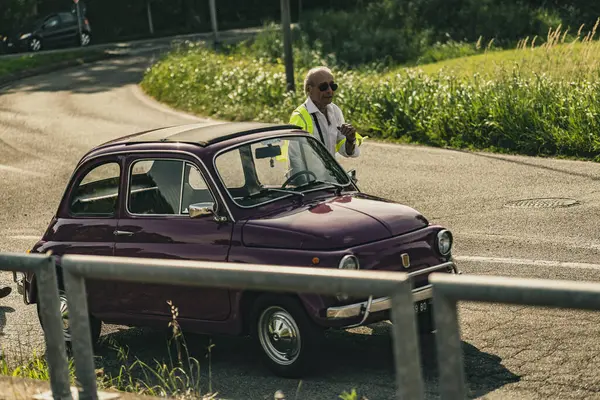 Milan, İtalya, 4 Haziran 2025, güneşli bir yaz gününde 500 'lü yılların klasik mitinginde yansıtıcı yelek giyen mareşal trafiği yönetiyor.