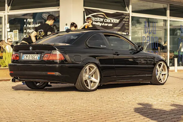 Milan, İtalya, 4 Haziran 2025, özel yapım siyah bmw e46 coupe araba yıkama yerinin önündeki kaldırımda park edilmiş, piyasa sonrası alaşım tekerlekleri sergileniyor.