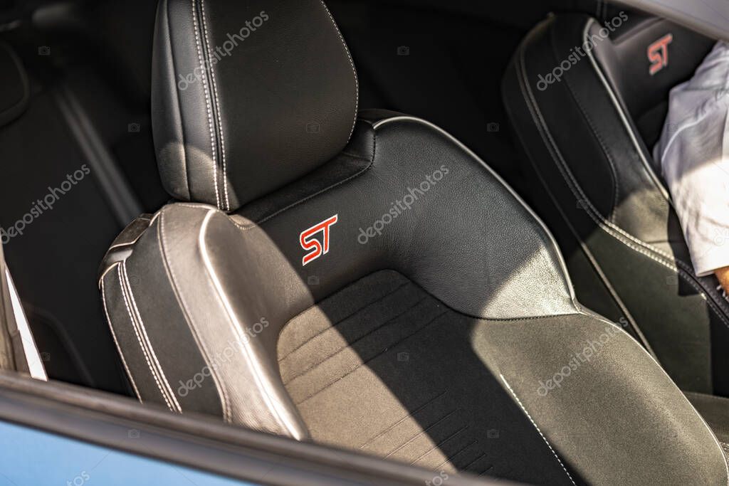 Milan, italy 4 june 2025, close up of black leather and fabric sport seats with prominent red st logo, highlighting the sporty interior of a modern vehicle