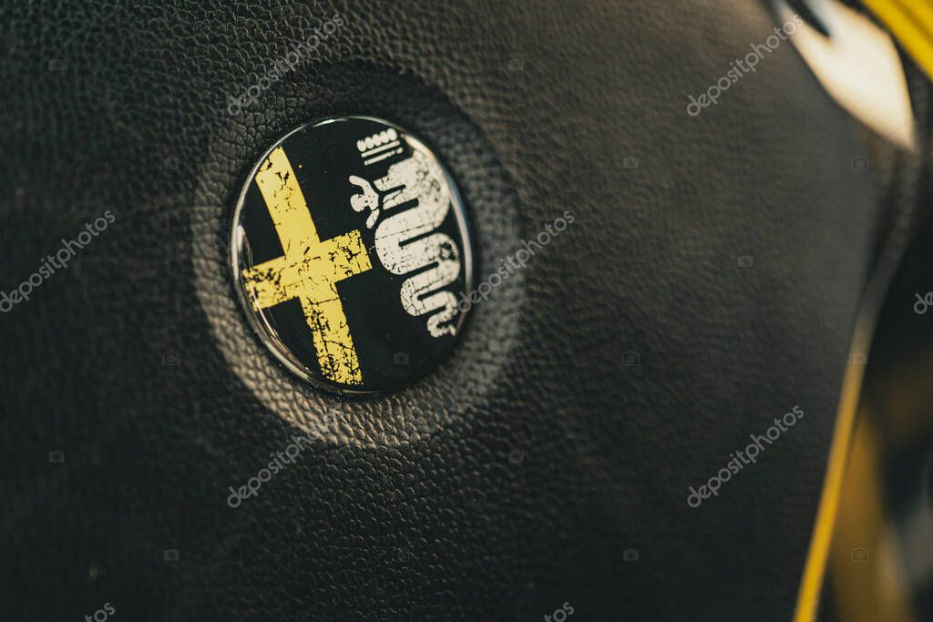 Milan, italy 4 june 2025, black leather steering wheel showcasing the iconic alfa romeo logo, celebrating italian automotive design and heritage