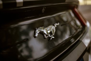 Roma, İtalya, 17 Haziran 2025, simgesel krom mustang at ambleminin arkasında parlak siyah bir Ford Mustang, sergilenen güç ve otomotiv mirası