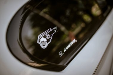 Roma, İtalya, 17 Haziran 2025, bir arabanın renkli camına yansıyan BMW logosunun kapağı, araba şevkini ve marka sadakatini gösteriyor