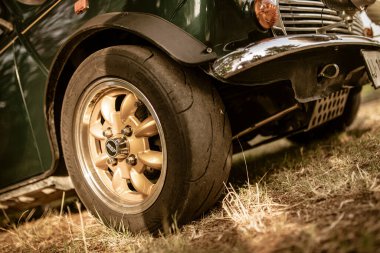 Roma, İtalya 17 Haziran 2025, alçak açı manzaralı, çimenli bir arazide park etmiş eski bir mini fıçının altın rengi çarkını vurguluyor.