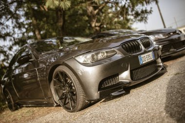 Roma, İtalya 17 Haziran 2025, güneşli bir yaz gününde ağaçların yakınına park edilmiş modern gri spor spor coupe BMW 'si