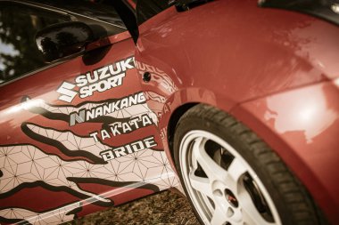 Roma, İtalya, 17 Haziran 2025. Nankang, Takata ve gelin gibi sponsor logoları olan kırmızı Suzuki spor bir arabanın yakınında.