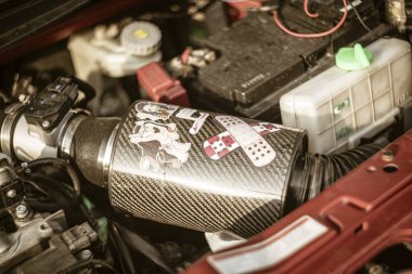 Roma, İtalya, 17 Haziran 2025, bir araba motoru kompartımanına yerleştirilmiş karbon fiber soğuk hava giriş sistemine yakın çekim, dekoratif çıkartmalar ve performans güncellemeleri
