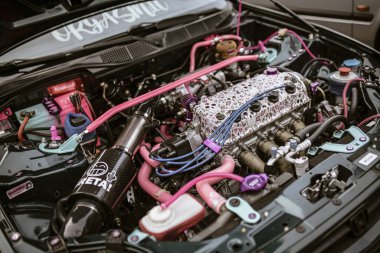 Roma, İtalya, 17 Haziran 2025, pembe ve deniz mavisi araba motoru akort ve performans modifikasyonları, benzersiz ve kişiselleştirilmiş bir stil sergiliyor.
