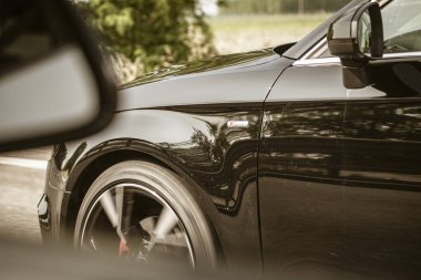 Roma, İtalya, 17 Haziran 2025, siyah bir Audi 'nin yoluna yakın, başka bir arabadan yan aynaya doğru gidiyor.