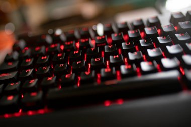 Işıklandırılmış klavyenin kapatılması oyun ve teknoloji temaları, kırmızı arka aydınlatma tuşları ve parlak bir siyah tasarım içerir