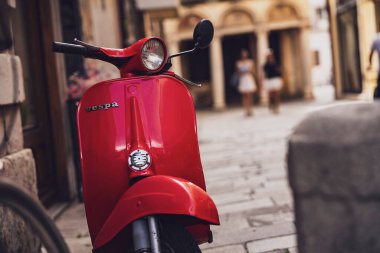 Padova, İtalya, 30 Haziran 2025, klasik kırmızı vespa Padua, İtalya 'da eski bir sokağa park edilmiş, İtalyan yaşam tarzının cazibesini somutlaştırıyor.