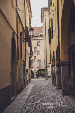 Padova, İtalya 30 Haziran 2025, büyüleyici dar kaldırım taşı caddesi Padua, İtalya, nostalji çağrıştıran tarihi binalar ve klasik fenerler ile kaplı.