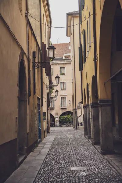 Padova, İtalya 30 Haziran 2025, büyüleyici dar kaldırım taşı caddesi Padua, İtalya, nostalji çağrıştıran tarihi binalar ve klasik fenerler ile kaplı.