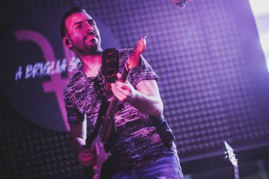 Padua, İtalya 8 Temmuz 2025, Mor sahne ışıkları altında canlı konser sırasında elektro gitar çalan müzisyen