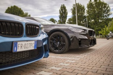 Roma, İtalya 18 Temmuz 2025, iki park etmiş BMW aracına yakın, biri mavi diğeri siyah, ön ızgaralarını, farlarını ve alaşım tekerleklerini gösteriyor.