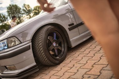 Roma, İtalya, 18 Temmuz 2025, piyasa sonrası jantları ve kaldırım taşlarına park edilmiş melek gözlü farları olan gri BMW E36 'yı akort etti.