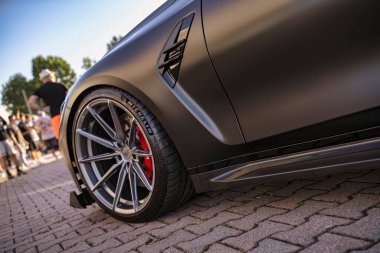 Roma, İtalya 18 Temmuz 2025, özel yapım spor bir arabanın alçak açılı görüntüsü. Piyasa tekerlerini, yan etekleri ve kaldırım taşlı bir caddeye park edilmiş çamurluk deliklerini aydınlatıyor.