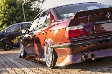 Roma, İtalya, 18 Temmuz 2025, özel yapım bordo bmw e36 park edilmiş, düşük süspansiyon, sonraki piyasa jantları ve bir arka spoiler da dahil olmak üzere modifikasyonlar sergiliyor.