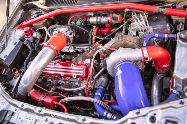 Roma, İtalya, 18 Temmuz 2025. Performans güncellemeleri, renkli hortumlar, turbo şarj aleti ve diğer modifikasyonları içeren özelleştirilmiş bir otomobil motorunu kapatın.