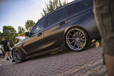 Roma, İtalya 18 Temmuz 2025, düşük açılı bir mat görüntüsü siyah akortlu BMW M3 turnesi açık hava ortamında piyasa alaşımlı tekerlekler ve vücut kiti sergileniyor.