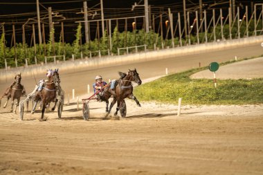 Padua, İtalya 18 Temmuz 2025, gece kum pistinde koşan yarış atları, bir at yarışında yarışan jokeyler.