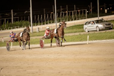 Padua, İtalya 18 Temmuz 2025, koşucular geceleri kum yolunda koşuyor, jokeyler koşum takımı yarışı şampiyonasında yarışıyor.