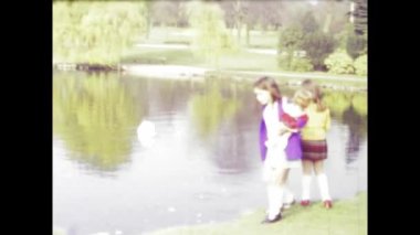 Alton, Birleşik Krallık 1978 yapımı nostaljik klasik film, çocukların huzurlu İngiliz parkı ortamında göl kenarındaki kuğuları nazikçe beslediğini gösteriyor.