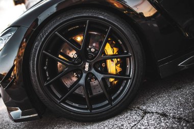 Roma, İtalya 5 Ağustos 2025: Sarı fren ayarlı şık siyah alaşımlı tekerlek, sergilenen performans ve otomotiv tasarımı