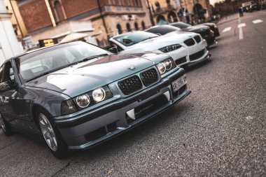 Roma, İtalya 5 Ağustos 2025: diğer arabalarla birlikte bir şehir caddesinde park etmiş özel tamponlu BMW E36