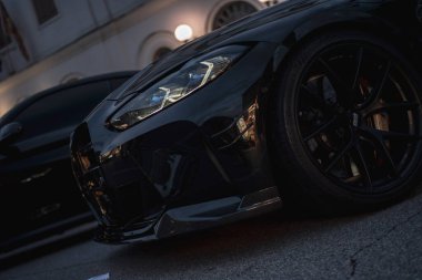 Roma, İtalya 5 Ağustos 2025: gösterişli siyah spor araba modern tasarımı ve güçlü varlığı gün batımında bir şehir caddesinde.