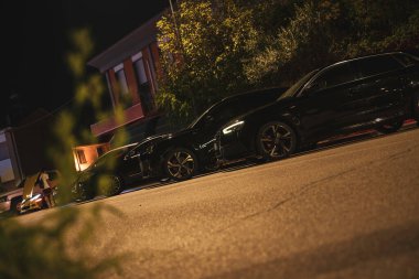 Calaone, İtalya 13 Ağustos 2025: Geceleri banliyö caddesini aydınlatan park edilmiş arabalar