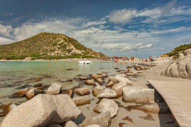 Punta molentis, İtalya 20 Ağustos 2025: Turkuaz sularda yüzen pedal botlar kayalık bir sahil kenarında turistlerin yaz tatilinin tadını çıkardıkları punta molentis, sardunya