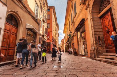 Bolonya, İtalya 19 Ağustos 2025: turistler, karakteristik turuncu binalarıyla İtalya 'nın büyüleyici caddelerini keşfediyorlar.
