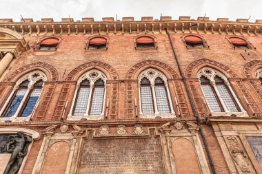 Bolonya, İtalya 19 Ağustos 2025: Bolonya, İtalya 'daki Palazzo della Mercanzia' nın düşük açılı manzarası, kemerli pencereler ve dekoratif tuğla ön cephe.