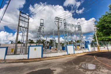 Bayahibe, Dominik Cumhuriyeti 19 Ağustos 2025: Bayahibe, Dominik Cumhuriyeti 'nde bulutlu bir gökyüzü altında elektrik dağıtan elektrik santrali