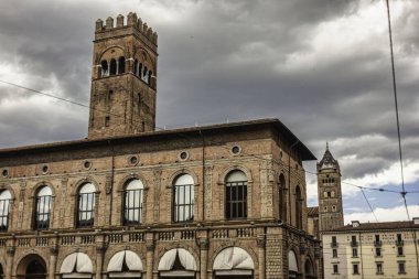 Bolonya, İtalya 19 Ağustos 2025: Palazzo della Mercanzia ve onun hassas kulesi Bolonya, İtalya 'daki Piazza Mercanzia' ya hakim dramatik bulutlu bir gökyüzü altında