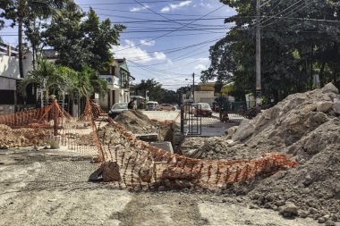 Tulum, Meksika 20 Ağustos 2025: Toprak ve kaya yığınları, turuncu güvenlik ağı ve bir hendek Tulum, Meksika 'da bir sokağı tıkayarak trafiği aksatıyor.