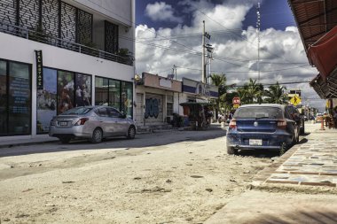 Tulum, Meksika 20 Ağustos 2025: Tulum pueblo, Meksika 'da tozlu, kumlu bir caddede park edilmiş arabalar, kentin ve tropikal elementlerin eşsiz karışımını gösteriyor.