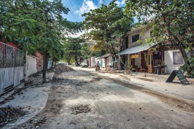 Tulum, Meksika 20 Ağustos 2025: Tulum Pueblo, Meksika 'daki tozlu, kumlu bir sokakta bisiklet süren yerel bir adam.